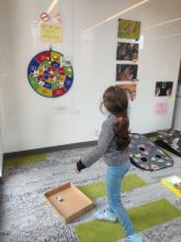 Young scientist playing bat game with Santana Lab