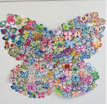 A colorful array of patterned paper butterflies arranged to form a large butterfly shape on a white background.