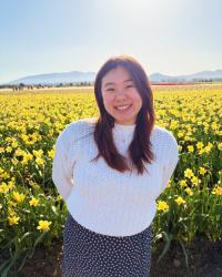 Image of Allison standing in a field of yellow tulips