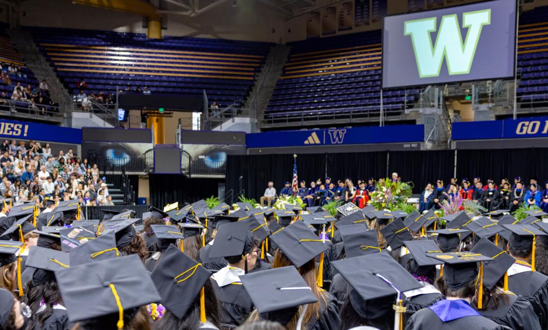 Graduates in caps and gowns seated in an arena during Biology 2025 graduation ceremony