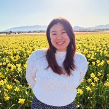 Image of Allison standing in a field of yellow tulips