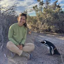 This image is of graduate student Meredith Honig sitting next to a penguin